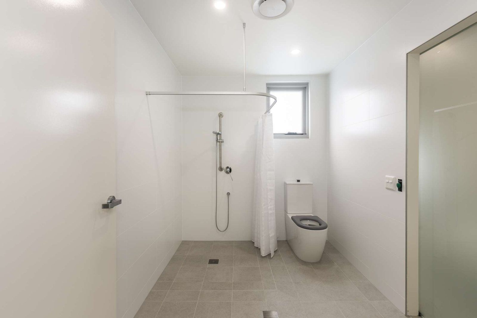 Photo 6 of 11: Accessible bathroom with a roll-in shower and grab rails