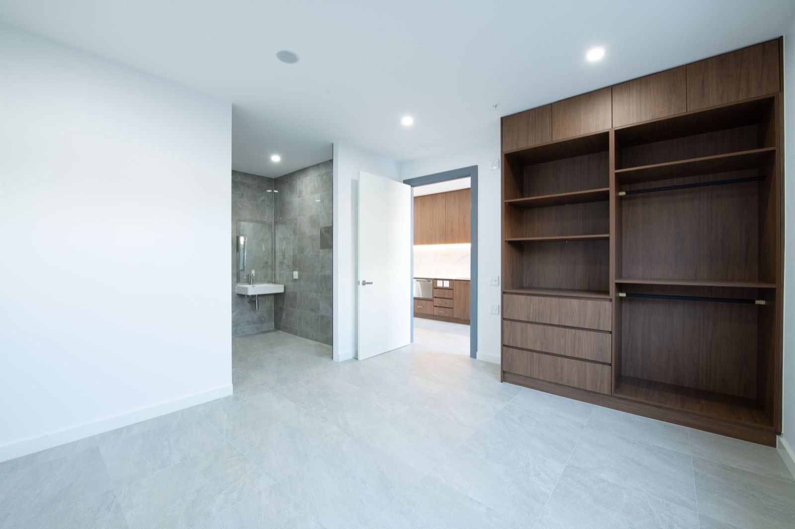 Photo 5 of 11: Bedroom with built-in timber wardrobe and shelving, and a doorway to the ensuite