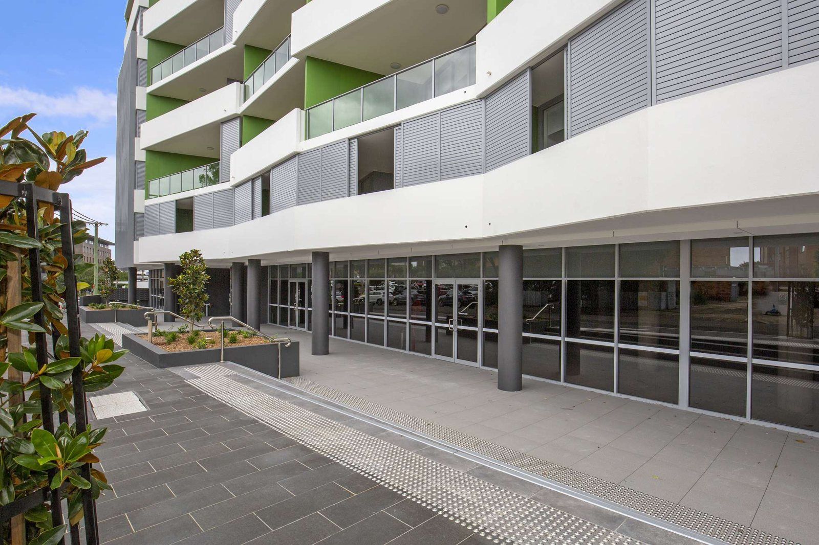 Photo 10 of 10: Building entrance and paved forecourt with planting