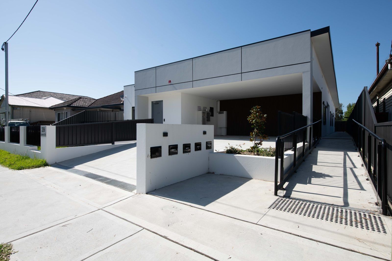 Front of the Louis Street villas in Granville, with a step-free ramp and handrail leading to the entrances