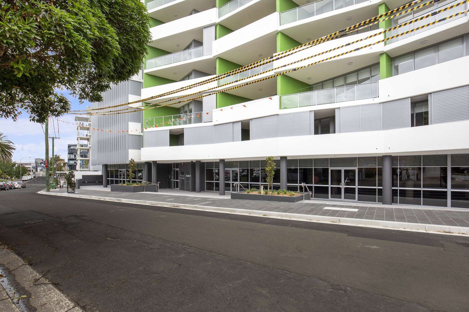 Modern six-level apartment building on Thomas Street, Wollongong, with green and white balconies