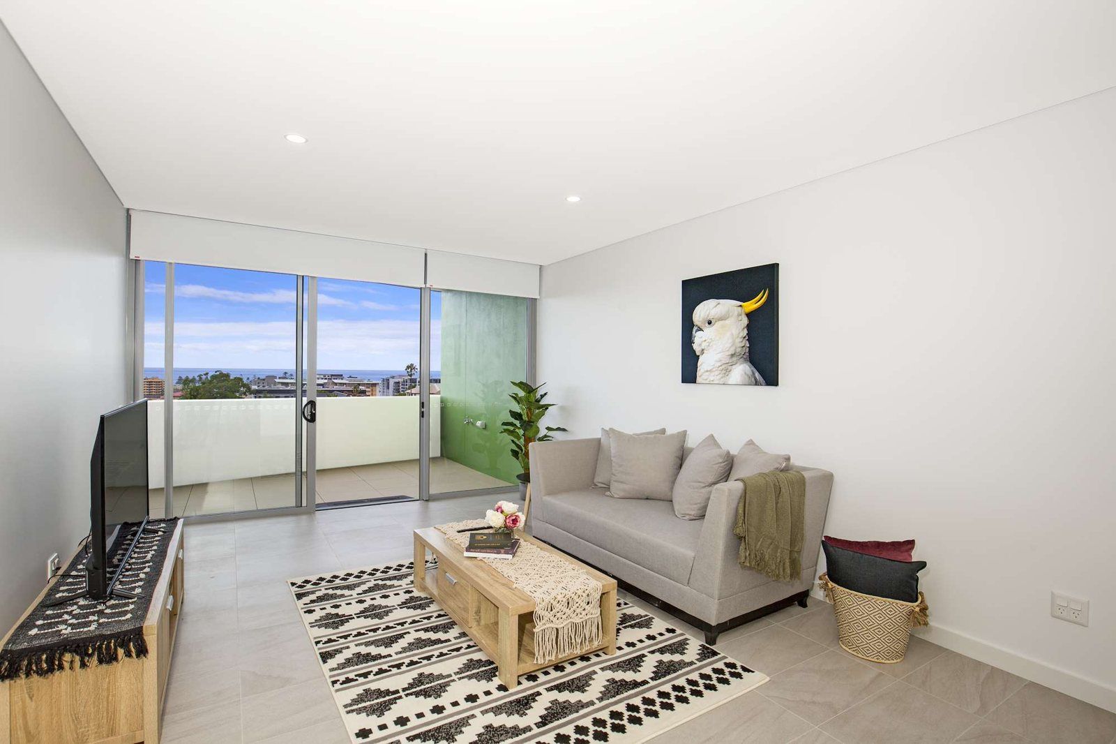 Photo 2 of 10: Bright living room with a sofa, rug and sliding doors to the balcony